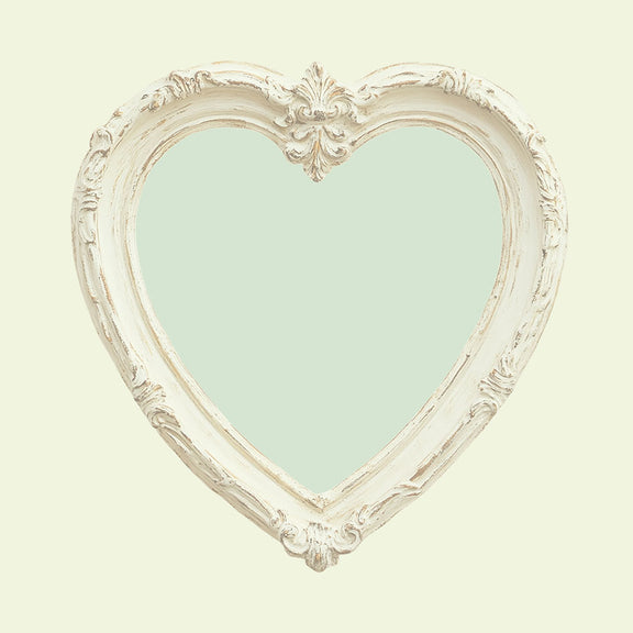 Achterzijde van een kaart met een pastelgroen hart in een witte barokke lijst, vintage stijl.