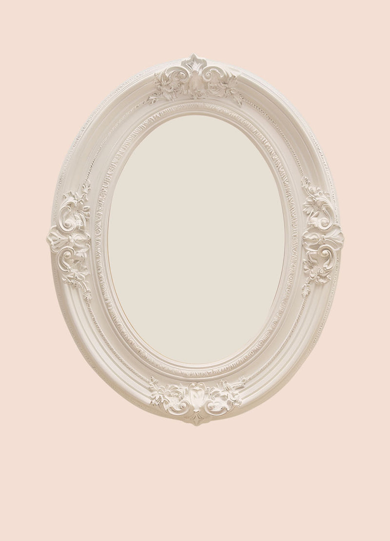 Zachtroze achtergrond met een witte ovale vintage sierlijst