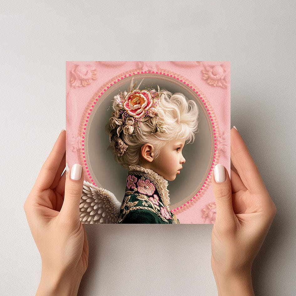 Mock-up van de Mozes engelkaart, met een jongen in barokke jas, roze rozen en zachte engelenvleugels, vastgehouden door twee handen tegen een lichte achtergrond.